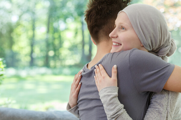 A cancer patient hugging their partner.