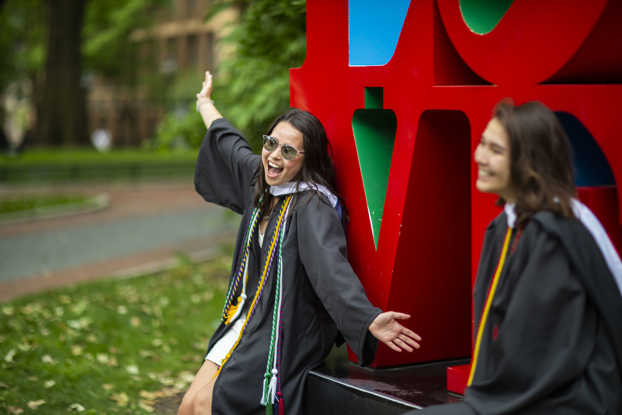 two students celebrating after Penn’s commencement at Robert Indiana’s LOVE statue.
